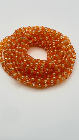 Golden amber ombre glass bead African waist beads, coiled on a neutral background