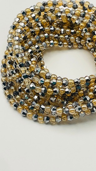 Metallic gold and silver mixed bead African waist beads, coiled on a neutral background