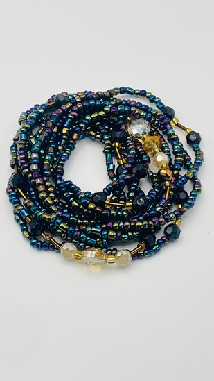 Peacock teal iridescent multicolor African waist beads with gold accent beads, coiled on a neutral background